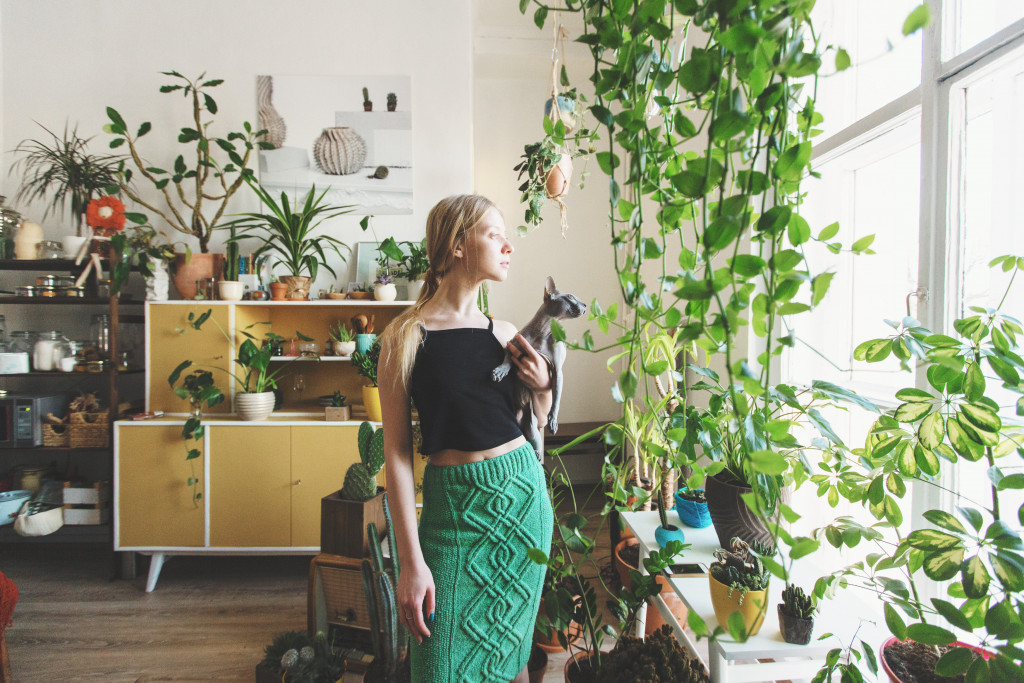 Frau mit Pflanzen in ihrem Haus
